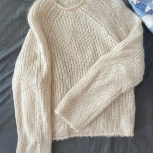 Vit stickad tröja från arket - Mysig vit stickad tröja från arket med grov ribbstickning. Tröjan har rund halsringning och långa ärmar. Perfekt för lager-på-lager och enkel att matcha med olika outfits.