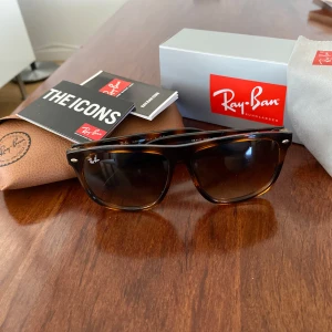 Ray-Ban Boyfriend solglasögon - Klassiska Ray-Ban Boyfriend solglasögon i brunsköldpaddsmönstrad plast med mörka glas. Modellen är RB 4147 och har en tidlös design med normal passform. Perfekt accessoar för dig som gillar stilrena och ikoniska solglasögon.