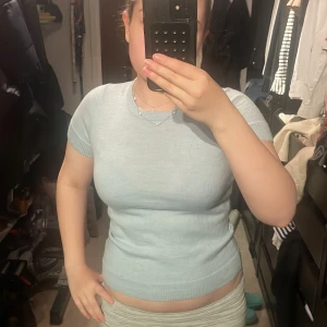 Ljusblå stickad topp från 2NDDAY - Säljer en ljusblå stickad topp från 2NDDAY med korta ärmar och rund halsringning. 