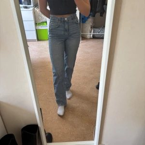 Blå raka jeans med hög midja 26 i midja - Säljer ett par klassiska blå jeans med raka ben och hög midja. Jeansen har knapp- och dragkedjegylf samt en tidlös tvätt. Perfekta för en avslappnad och stilren look. 