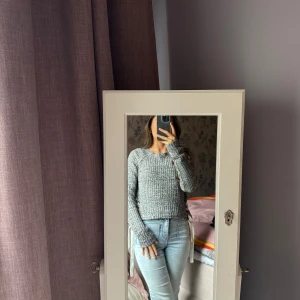 Grå stickad tröja - Säljer en grå stickad tröja med snörning på sidorna.