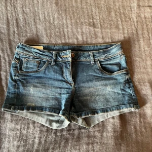 Blåa lågmidjade jeansshorts  - Super snygga blåa och lågmidjade jeansshorts. De är jättebekväma, de är i storlek 38 och är från Clockhouse by C&A. Perfekta för sommaren! 