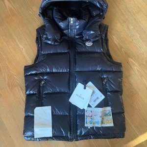 Moncler lacet väst - En sjukt fet Moncler lacet väst i riktigt bra skick. Ett litet pinhole som visas på bild samt är Catrine avklippta men medföljer vid köp. Samt kvitto och tags medföljer också. Storlek 1 ~ S/M på denna modellen. Marinblå färg. 