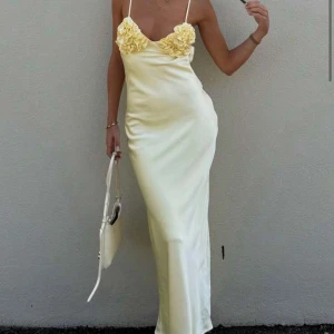 Gul långklänning - Säljer denna långklänning med smala axelband och vackra blommiga volangdetaljer🙌🏻Klänningen är helt ny och aldrig använd då jag råkade beställa dubbelt! Perfekt för sommarens speciella tillfällen. Skriv för egna bilder🫶