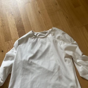 Vit långärmad topp från Mirelle - Säljer en stilren vit långärmad topp från Mirelle. Toppen har en enkel och klassisk design med rund halsringning och är tillverkad i ett mjukt, slätt material. Perfekt att matcha med olika outfits. Hittar ingen storlek lapp men är runt S/M