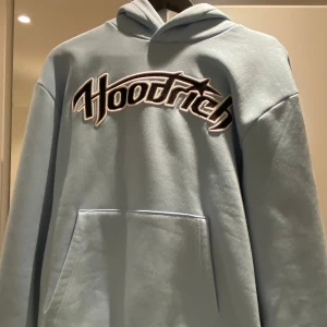 Ljusblå hoodie och mjukisbyxor från Hoodrich - Säljer ett set med ljusblå hoodie och matchande mjukisbyxor från Hoodrich. Hoodien har stor logga framtill och på huvan, samt känguruficka. Byxorna har i midjstor logga framtill. Perfekt för en avslappnad stil. Hoodie i storlek S, byxan i storlek L