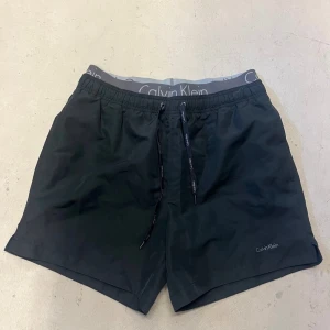 Calvin Klein svarta badbyxor - Svarta badbyxor med resår i midjan, aldrig använda. Storlek M. Nypris 600kr