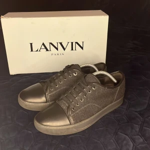 Lanvin sneakers  - Tja just nu Säljer ett par svarta sneakers från Lanvin med ovandel i filt och matt läder captoe. skorna är i bra skick med några små skavanker som ej märks av vid användning. skon är i storlek sju men passar mig som har 43-42. Obs endast skorna ingår. Nypris ligger runt 5000 medan jag säljer för endast 1700. Men priset är så klart diskuterar bart. Jag tar gärna byten som vanligt och så får jag önska er en fortsatt trevlig dag. Med vänliga hälsningar Oscar