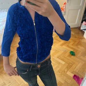 blommig kofta från Bershka - Säljer en kornblå kofta från Bershka med dragkedja och 3/4-ärmar. Cool tröja aldrig använd säljer för 75kr går att diskutera!