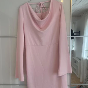 Ljusrosa klänning med draperad rygg - Säljer en ljusrosa klänning med lång ärm och snygg draperad rygg med knytband