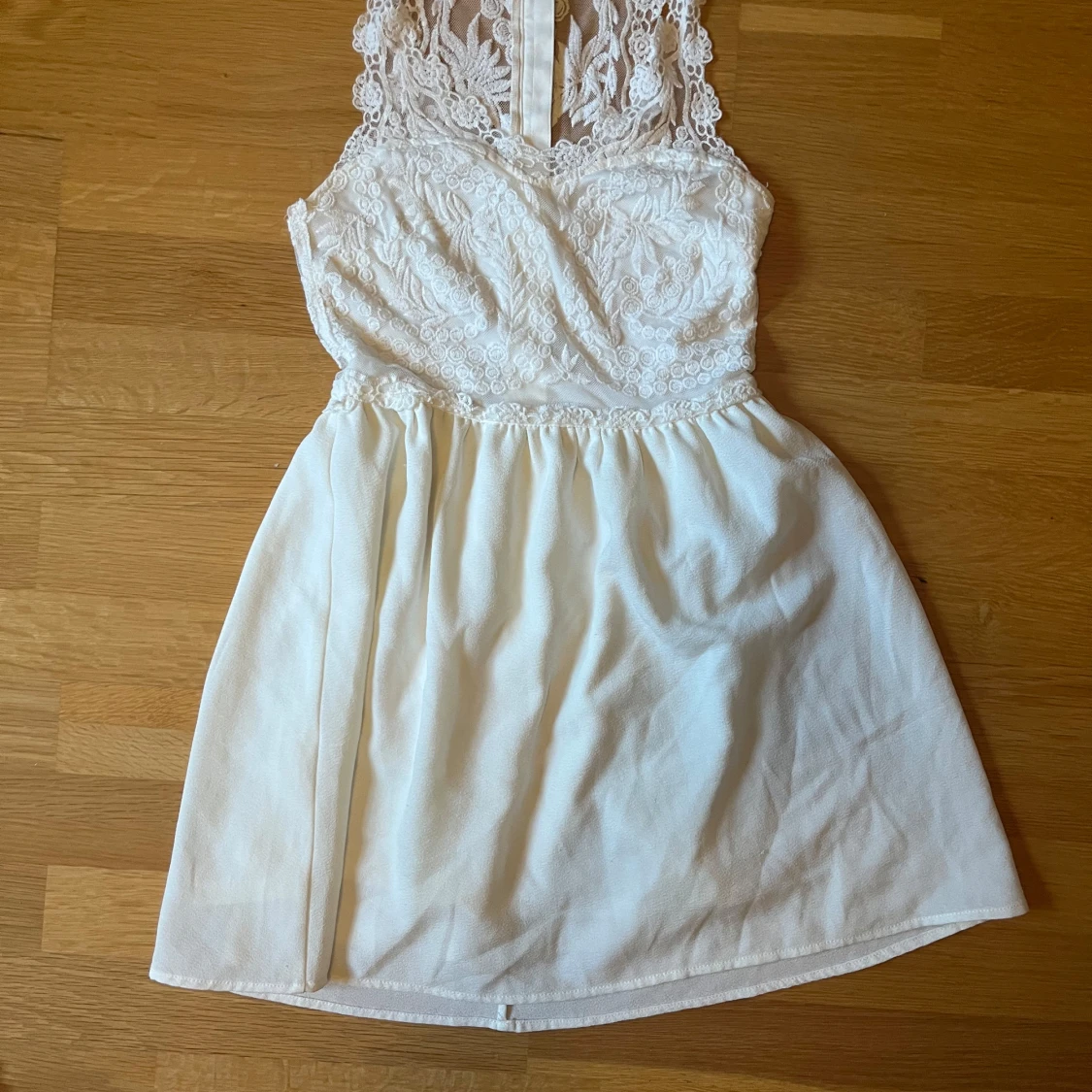 Vit spetsklänning med ärmlös design