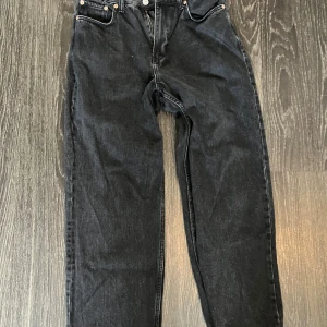Svarta Weekday Galaxy Loose Straight Jeans - Säljer ett par svarta jeans från Weekday i modellen Galaxy Loose Straight. Jeansen har en rak och loose passform med klassisk femficksdesign och knappgylf. Perfekta för dig som gillar en avslappnad stil med bredare ben.