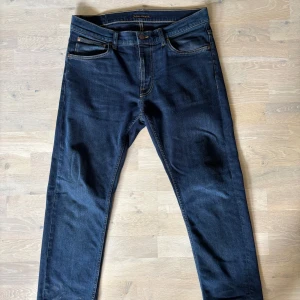 Mörkblå jeans från Nudie Jeans - Säljer ett par mörkblå jeans från Nudie Jeans i modellen Lean Dean och har en slim passform. Storlek W32 & L30 (dock uppsydda och är mer som L28)