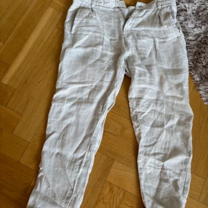 Beiga linnebyxor från Zara - Säljer ett par beiga linnebyxor från Zara med normal passform. Riktigt feta att ha till sommarenByxorna har dragkedja och knapp . Säljer pågrund av växt ur. Använt de ett fåtal gånger så det är bra skick, köpte de för 499