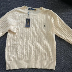 Vit kabelstickad tröja från Polo Ralph Lauren - Säljer en klassisk vit kabelstickad tröja från Polo Ralph Lauren.