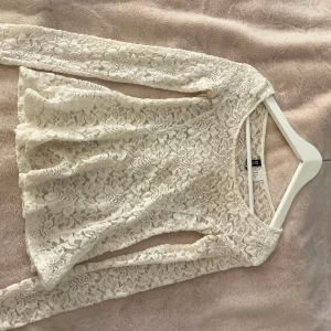 Vit spets tröja - Säljer en vit blus i spets med lång ärm. Blusen har ett vackert blommigt spetsmönster, perfekt att styla med jeans eller kjol. Säljer pga att jag växt ur den, dvs får inte över den över bröstet tyvärr. 🩷