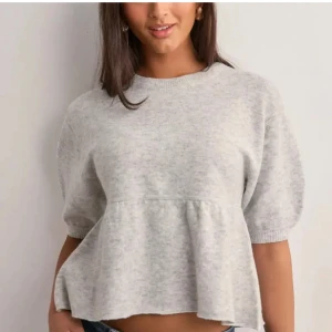Grå stickad topp med volang - Superfin ljusgrå stickad topp med korta ärmar och volang nedtill
