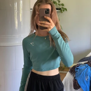 Turkos croppad långärmad träningströja från Gymshark - Säljer en turkos croppad långärmad träningströja från Gymshark. Tröjan är lätt, men inte genomskinlig alls och sitter inte tight. Fick den i present och har inge använt den någon gång så den är som ny. Gillar bara inte att träna i croptops.
