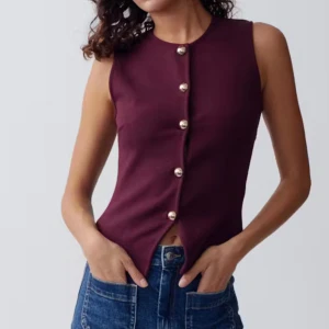 Vinröd ärmlös topp med pärlknappar - Säljer en vinröd ärmlös topp med snygga pärlknappar framtill från Gina Tricot. Materialet känns mjukt och lent. Aldrig använd!!!