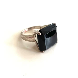 Silverplätterad ring med svart sten (ej äkta) retro/ vintage look - Snygg ring som ser mycket äkta ut även på nära håll. Den är silverplätterad och det finns stämplar som är svåra att få bra bild av (men försökt, se foto). Stenen är inte äkta utan i ett hårt glas material. Mått på stenen:  2x2 cm Vikt ring 6,55 gram