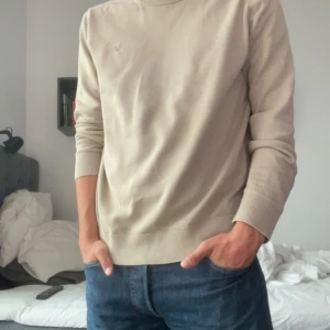 Beige Morris Tröja  - Snygg Morris Tröja som funkar perfekt till sommaren och framhävar brännan bra. Storlek M och passar mellan 174-182. Modellen på bilden är 177 och sitter bra! Bra skick och nypris runt 600kr+