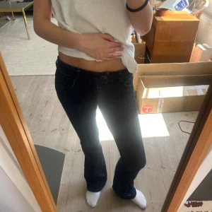 Mörkblå bootcut jeans - Säljer ett par mörkblå jeans med bootcut passform. Klassisk femficksmodell med låg midja och kontrastsömmar. Perfekta för dig som gillar en tidlös jeansstil.
