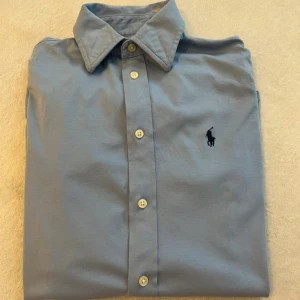 Ralph Lauren skjorta - Hej säljer nu min fina Ralph lauren skjorta i storlek S Dam. Den är i bra skick man kan se effekterna i bilderna och kommer vara otroligt snygg nu i vår och framåt sommaren. Nypris cirka 1600kr! Vi kommer att sälja liknande produkter nu i vår och närmare sommar så glöm inte följa profilen!🌊🍾