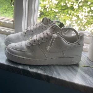 Nike Air Force 1 vita -  Kan sänka pris men inte för mycket !Klassiska Nike Air Force 1 i helvitt skinn med lågt skaft och perforerad tå. Snygg och tidlös modell med rund tå, platt sula och snörning. Perfekta för dig som gillar en clean och sportig look. Skorna kommer med originalkartong om de går att frakta med. 