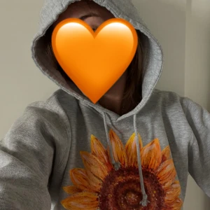 Grå hoodie med fin solros 🌻  - Säljer en grå hoodie med en stor fin solros tryckt på framsidan. Tröjan har huva med dragsko och en klassisk magficka. Perfekt för dig som vill ha en mysig och snygg tröja med unik detalj 💛står S men passar bra på M 