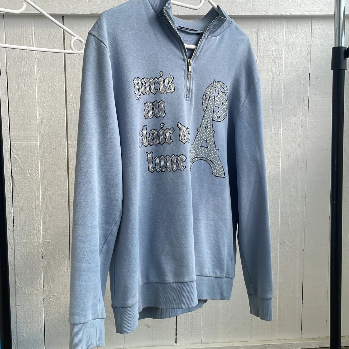 Ljusblå hoodie med dragkedja och Paris-tryck