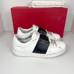 Valentino Open Sneaker - Klassiska Valentino Open Sneaker med svart stripe. Box & dustbags medföljer. Skick: 8/10. Retail: 7,300 SEK.