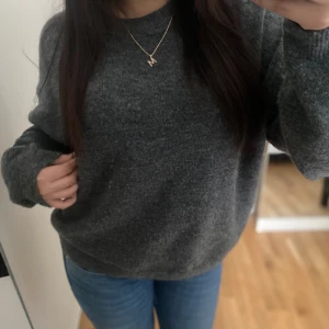 Mörkgrå stickad tröja från H&M - Mysig mörkgrå stickad tröja från H&M med rund halsringning och långa ärmar. Tröjan har en avslappnad passform och är superbekväm. Strl (M), Skriv vid funderingar 💬💗