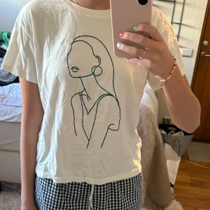 Vit t-shirt med tryck  - WVit t-shirt med ett grönt tryck på💚🤍