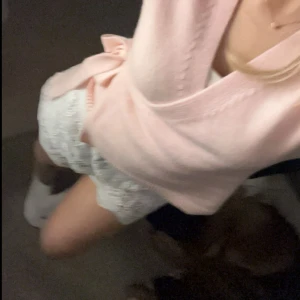 Ljusrosa stickad omlott tröja  - Säljer en söt ljusrosa stickad kofta med klassisk design. Koftan har långa ärmar och en mjuk, bekväm känsla. Perfekt att slänga över en topp för en chill och stilren look.