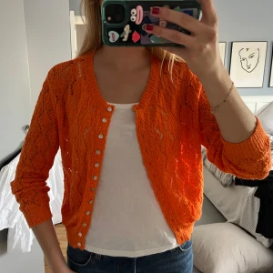Orange virkad kofta från Zara - Säljer denna orangea virkade koftan med pärlknappar. Den är lätt genombruten i mönstret. Perfekt att slänga över ett linne eller t-shirt i sommar🧡🧡