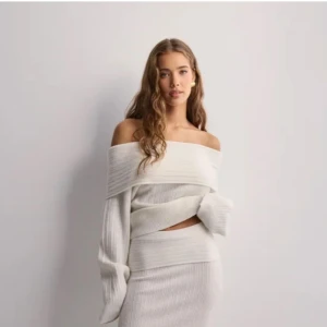 Offshoulder stickad tröja - Säljer en snygg offshoulder tröja i vitt med ribbad struktur. Tröjan har långa ärmar och en bred krage över axlarna. Perfekt för dig som vill ha en trendig och stilren look. Pris är diskuterbart.