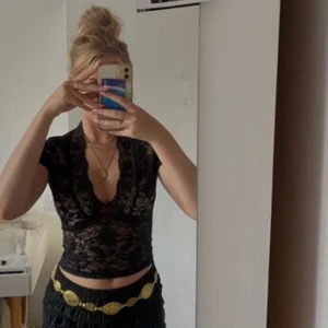 Svart spets topp - Säljer en svart topp i spets med korta ärmar och djup v-ringning. Perfekt för att styla med höga byxor eller kjol. Superfin detalj med spetsmönster över hela toppen! Tryck på KÖP NU så postar jag så snabbt som möjligt!! 🩷🩷