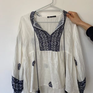 Blus  från Zara - Säljer en luftig vit blus från Zara med mörkblå  detaljer och knytband vid halsen. Perfekt för vår och sommar.Aldrig använd!❤️