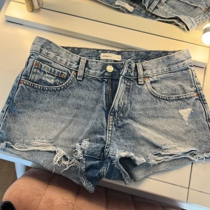 Lågmidjade jeansshorts  - Snygga blå jeansshorts från Gina Tricot med fransiga benslut och slitna detaljer. Klassisk femficksmodell med knapp och dragkedja framtill. Om man vill ha mått är det bara att skriva. Pris kan diskuteras!!💗