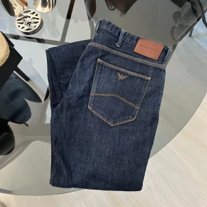 Mörkblå jeans från Emporio Armani - Säljer ett par mörkblå jeans från Emporio Armani med klassisk femficksdesign. Byxorna har en rak passform med stretch. 