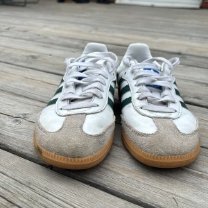Adidas Samba sneakers i vitt och grönt stlk 36 - Klassiska Adidas Samba sneakers med vit ovandel i skinn, gröna ränder. Mycket gott skick