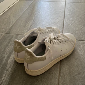 Vita Adidas Stan Smith sneakers - Klassiska vita Adidas Stan Smith sneakers med gröna detaljer på hälen. ☀️ Använda max 2 gånger. 