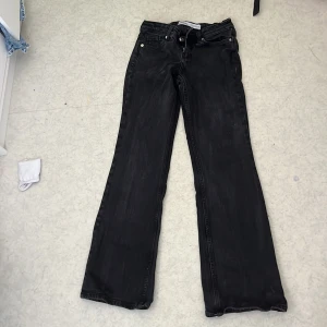 Svarta bootcut jeans från Bershka - Säljer ett par svarta jeans från Bershka med bootcut och klassiska femficksdetaljer. Jeansen har låg midja och utsvängda ben.  Storlek 32. Köpte för 400kr. Skulle nog säga att de passar för 155-160 cm