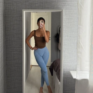 Ljusblå sömlösa leggings - Säljer ett par ljusblå sömlösa leggings med hög midja och mesh-detaljer längs benen. De är tighta och stretchiga, perfekta för träning eller chill. Snygg passform som framhäver benen och sitter skönt i midjan.