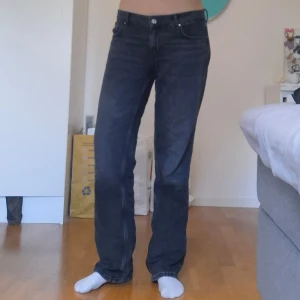 Svarta raka jeans - Säljer ett par svarta raka jeans med klassisk femficksdesign och normal passform. Jeansen har låg midja och raka ben. Perfekta för dig som gillar en tidlös och avslappnad stil.