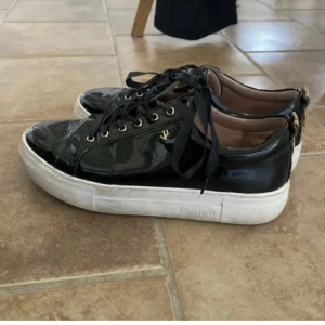Svarta sneakers - Snygga svarta sneakers i glansigt lack material. Tvättar en extra gång innan jag skickar iväg💕 skriv om ni har frågor!