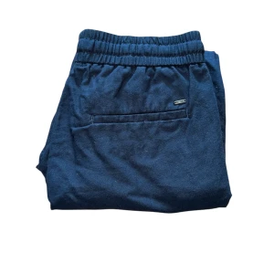 Linneshorts Only&Sons - Snygga mörkblå shorts med elastisk midja och snörning framtill. Shortsen har sidofickor och en bakficka med liten logotyp. Perfekta för varma dagar och enkel stil.