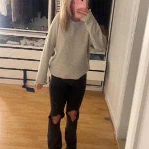 Beige stickad tröja - Mysig beige stickad tröja med rund halsringning och långa ärmar. Enkel och stilren design som passar perfekt till vardags. Tröjan har en rak passform och ribbade muddar vid ärmslut och nederkant.