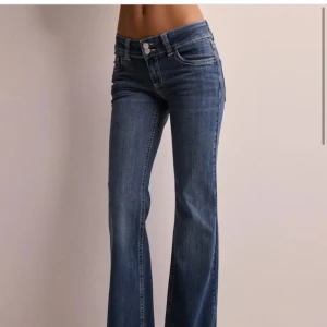 Low waist bootcut stitch jeans - Lågmidjade blå jeans från Nelly med mönster på bakfickorna. Använda men inga tydliga tecken på slitage. Nypris 699kr ‼️OBS pris kan diskuteras vid snabb affär‼️