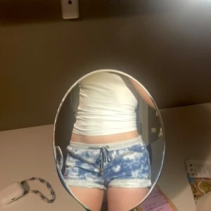 Blåvita shorts från Billabong - Säljer ett par blåvita shorts från Billabong med batikmönster och grå midja med dragsko. Shortsen har uppvikta benslut och en liten röd logga framtill. Perfekta för sommaren!